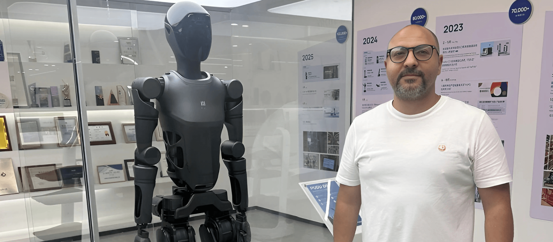 Hatem Elkady, CEO of Diamond Professional Consultants, standing next to a humanoid robot in China.